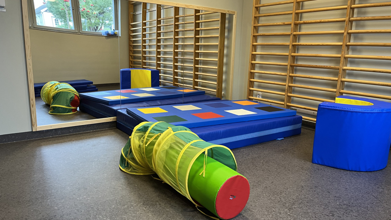 Madrasser och leksaker i ett rum med en stor spelgel.
